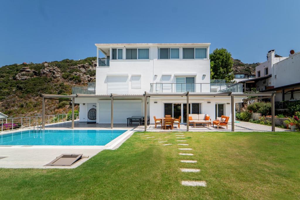 a white house with a swimming pool and a yard at Villa w Pool Garden Patio 1 min to Beach in Bodrum in Yalıkavak