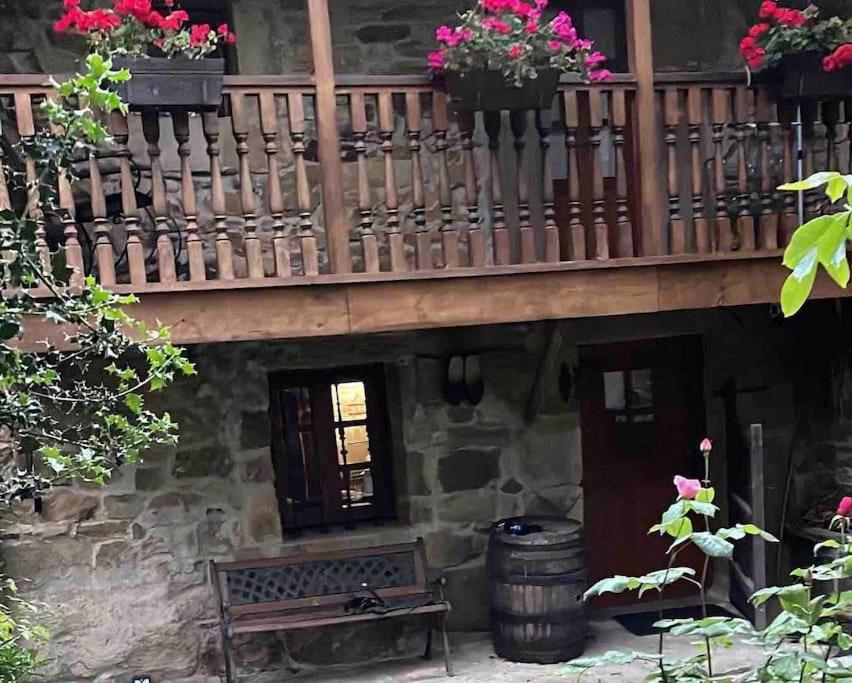 un balcón de madera con macetas y un banco en Casa El Nogal, en Los Pandos