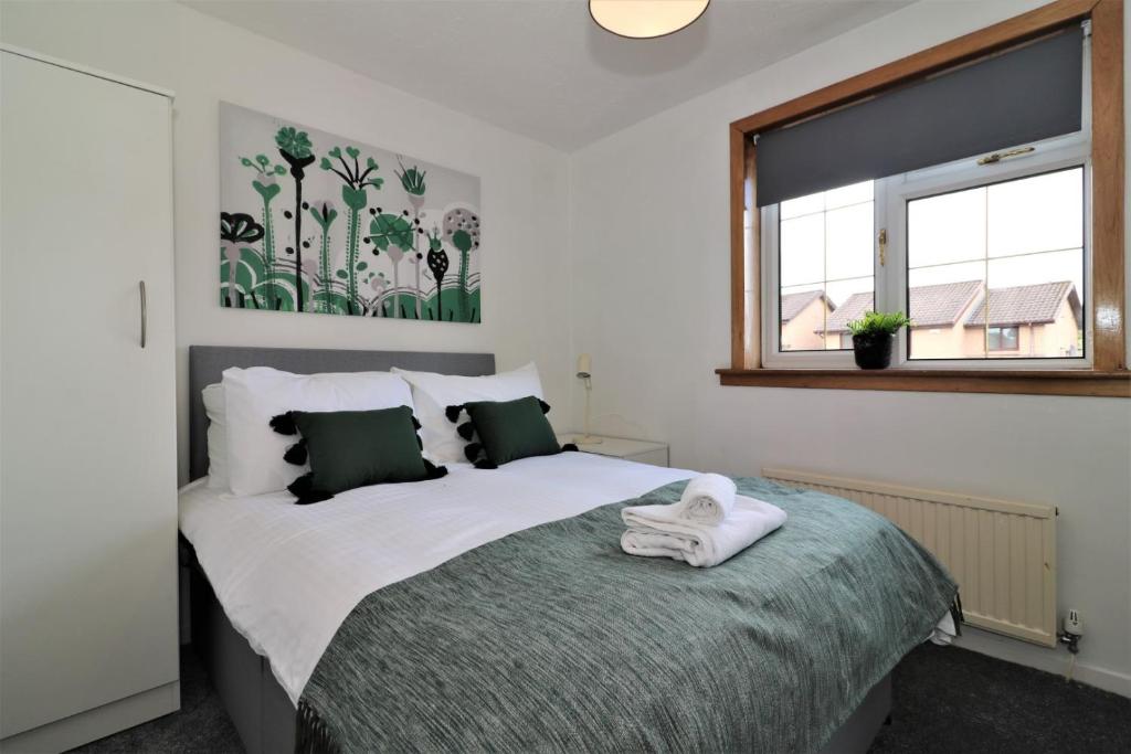 a bedroom with a bed with a towel on it at Signature - Binnie House in Cumbernauld