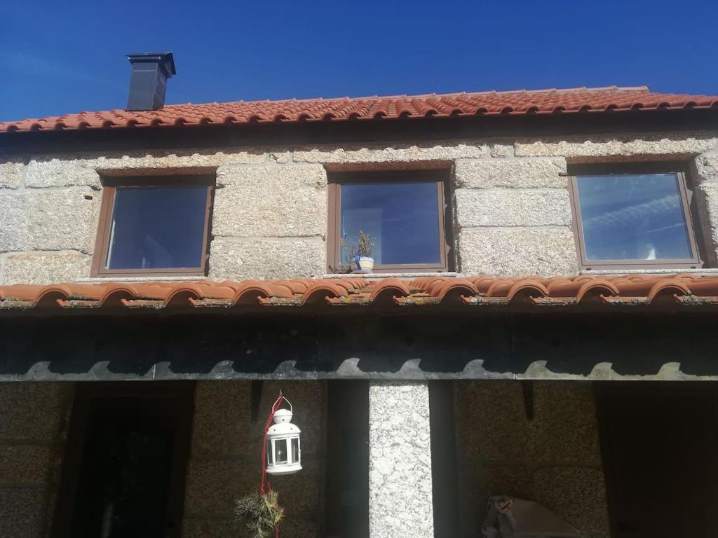 un bâtiment avec trois fenêtres et un toit dans l'établissement Beiral da Marfida, à Amarante