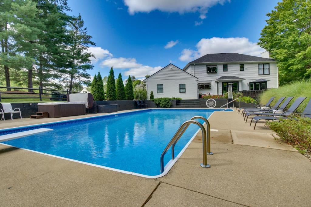 a swimming pool in front of a house at Luxury Maineville Villa with Private Pool and Deck in Maineville