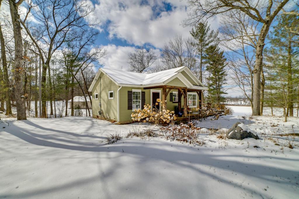 una pequeña casita verde en la nieve en Cozy Lakeside Cottage Pontoon, Kayaks, Grill, en Newaygo