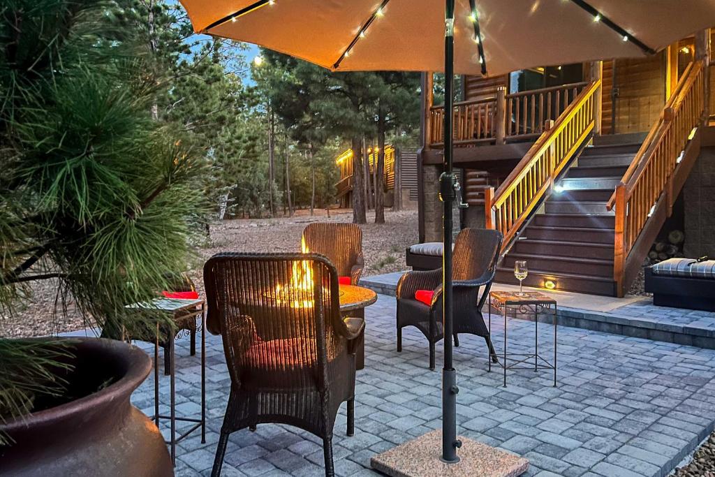 eine Terrasse mit Stühlen und einem Tisch mit einem Sonnenschirm in der Unterkunft Cozy Torreon Cabin Close to Golfing and Hiking! in Show Low