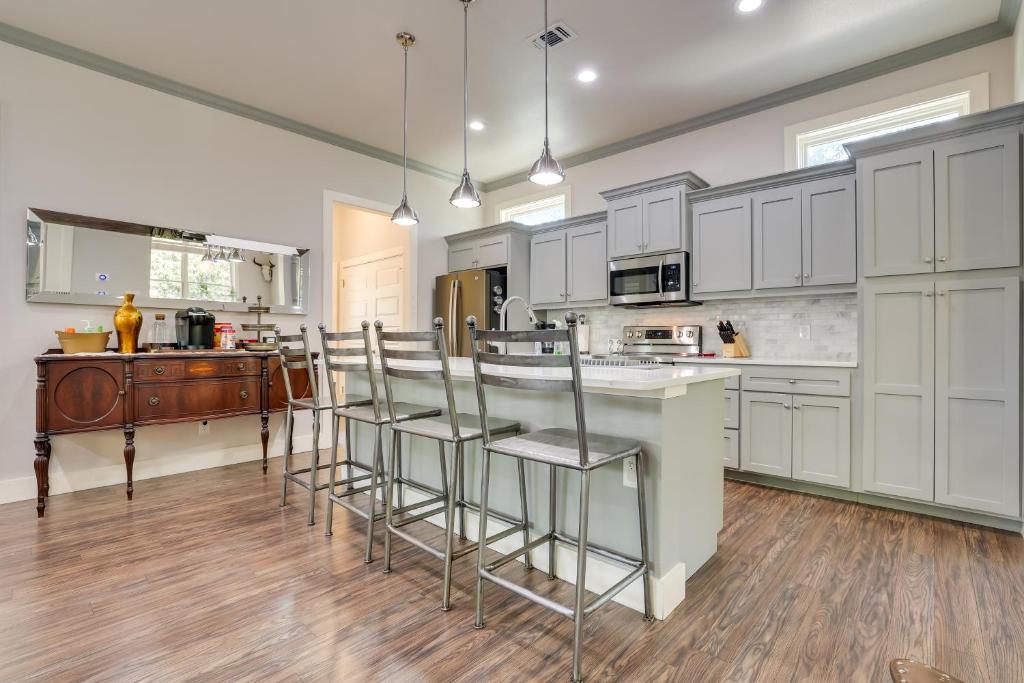a kitchen with white cabinets and a island with bar stools at Modern San Antonio Retreat Less Than 1 Mile From Downtown! in San Antonio