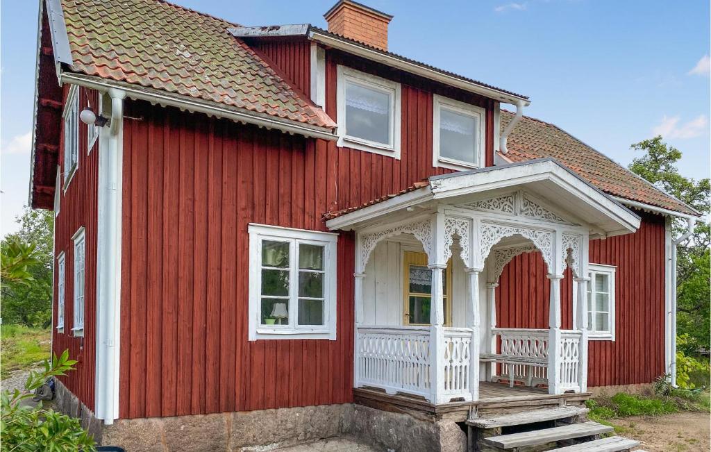 una casa roja con un cenador blanco en 4 Bedroom Beautiful Home In Vimmerby, en Vimmerby