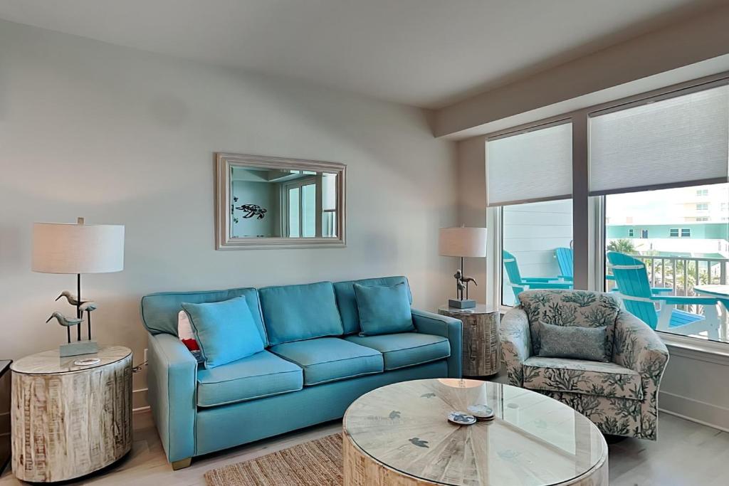 a living room with a blue couch and a table at Sea Glass #211 in Gulf Shores