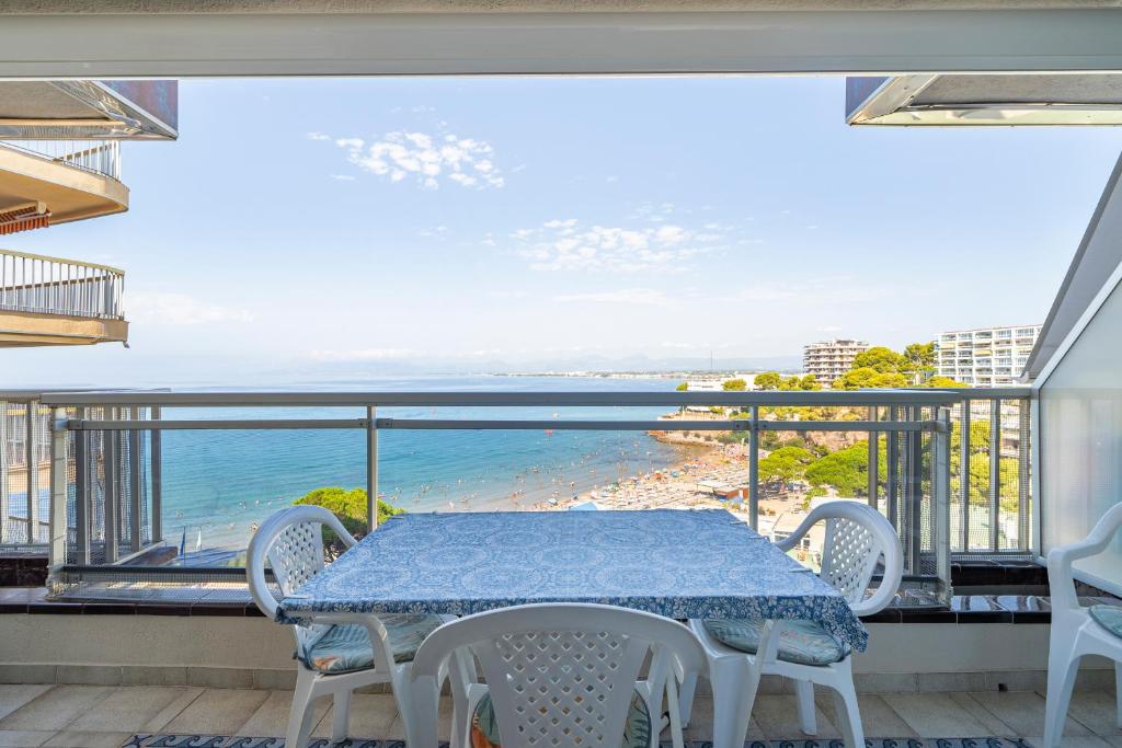 einen Tisch und Stühle auf einem Balkon mit Meerblick in der Unterkunft Hauzify I Apartament Capellans in Salou