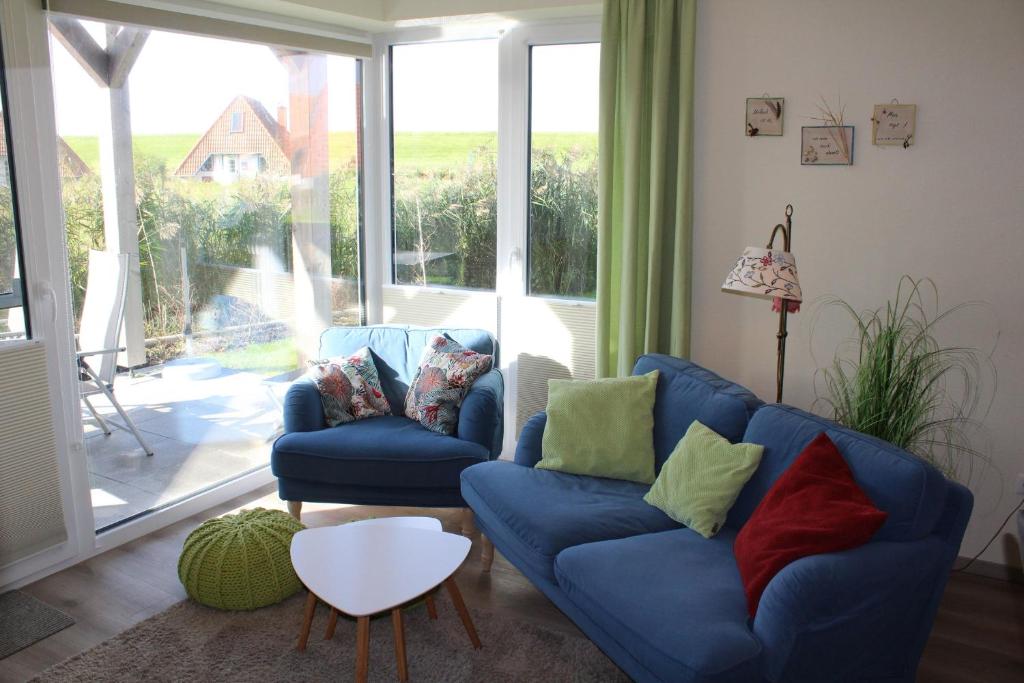 a living room with two blue couches and a window at LM 9-1-1 - Ferienwohnung Wremer Bogen Komfort in Schottwarden