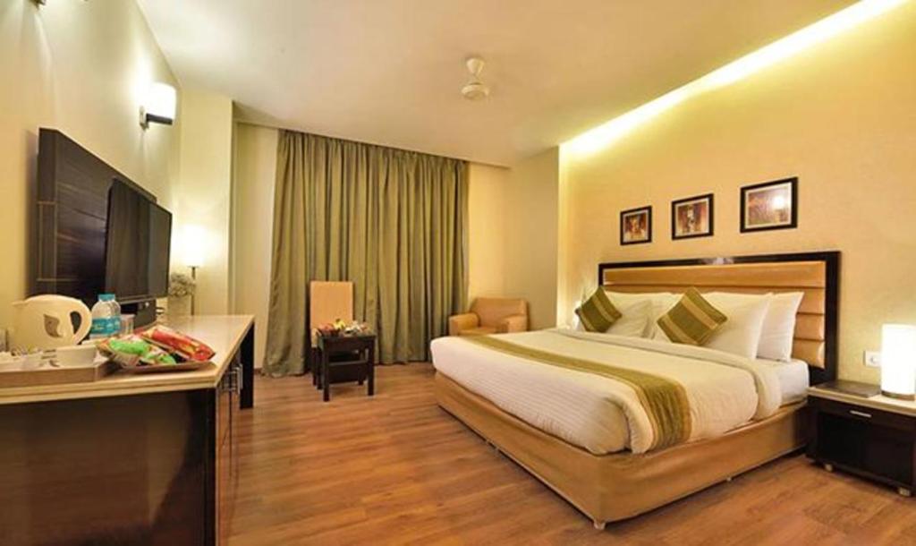 Habitación de hotel con cama y escritorio en FabHotel Prime The Western, en Nueva Delhi