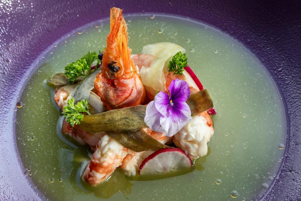 a plate of food with shrimp and a flower on it at Melia Vienna in Vienna