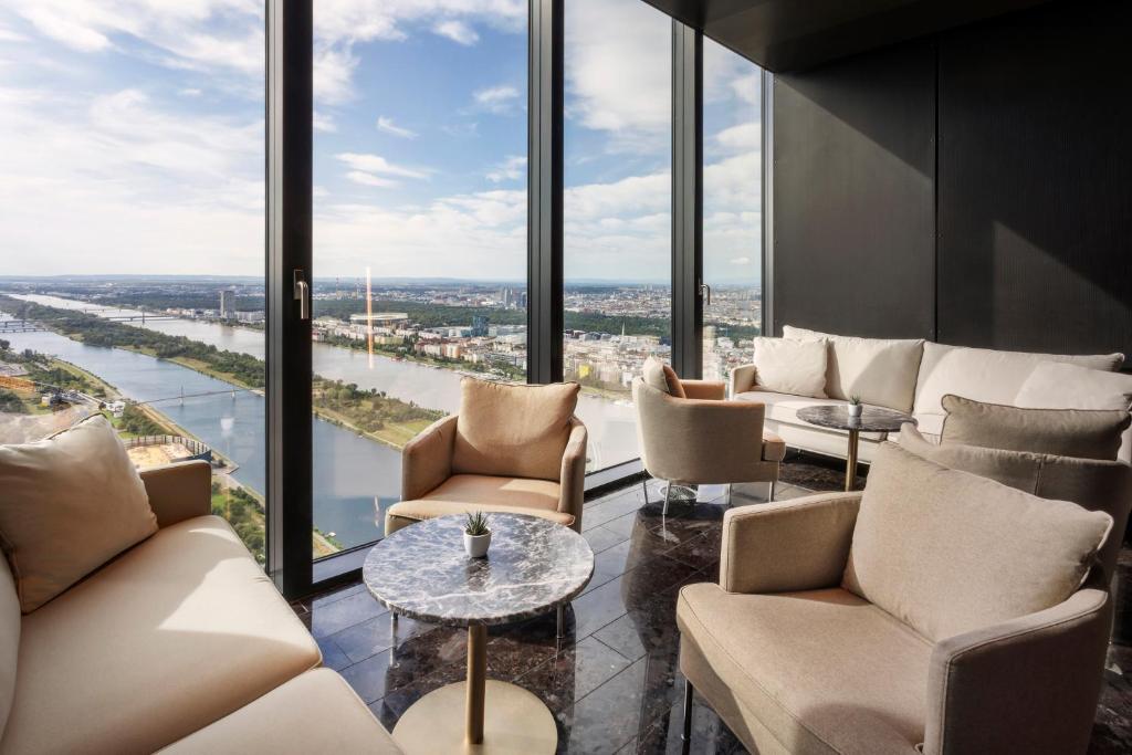 a room with couches and tables and large windows at Melia Vienna in Vienna