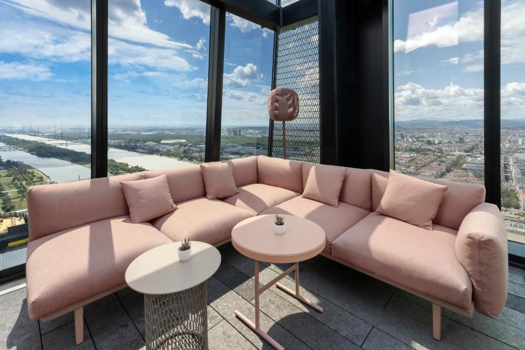 a couch in a room with tall windows at Melia Vienna in Vienna