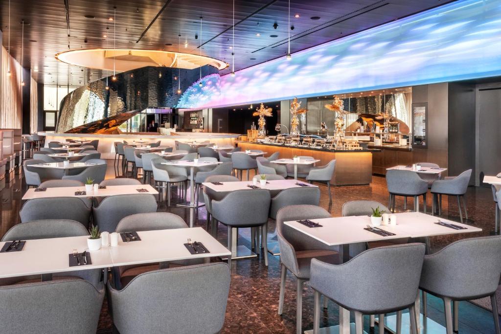 a restaurant with tables and chairs and a bar at Melia Vienna in Vienna