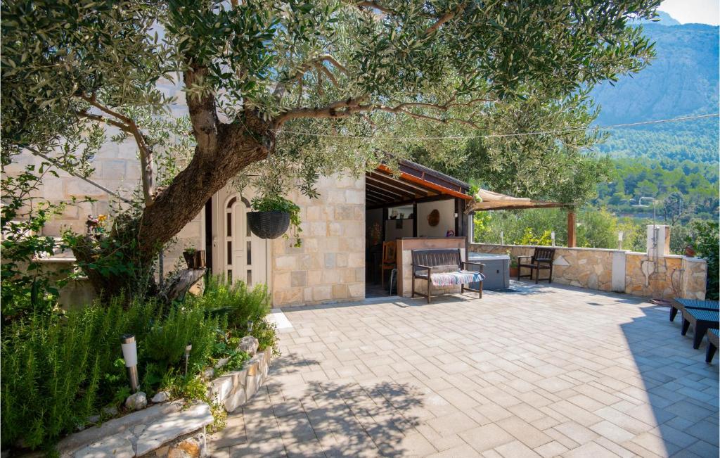 un patio con un árbol, una mesa y sillas en Stunning Home In Makarska With 1 Bedrooms And Wifi, en Makarska