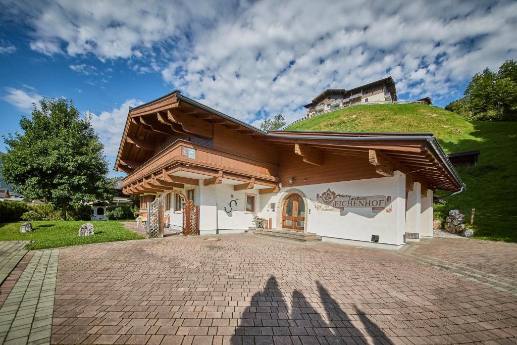 una casa con una colina verde encima de ella en Landhaus Eichenhof, en Saalbach Hinterglemm