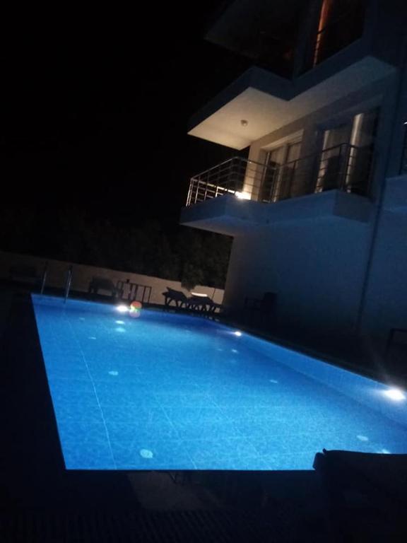 una piscina frente a una casa por la noche en DALGIÇ SUİT POOL CLUB, en Fethiye