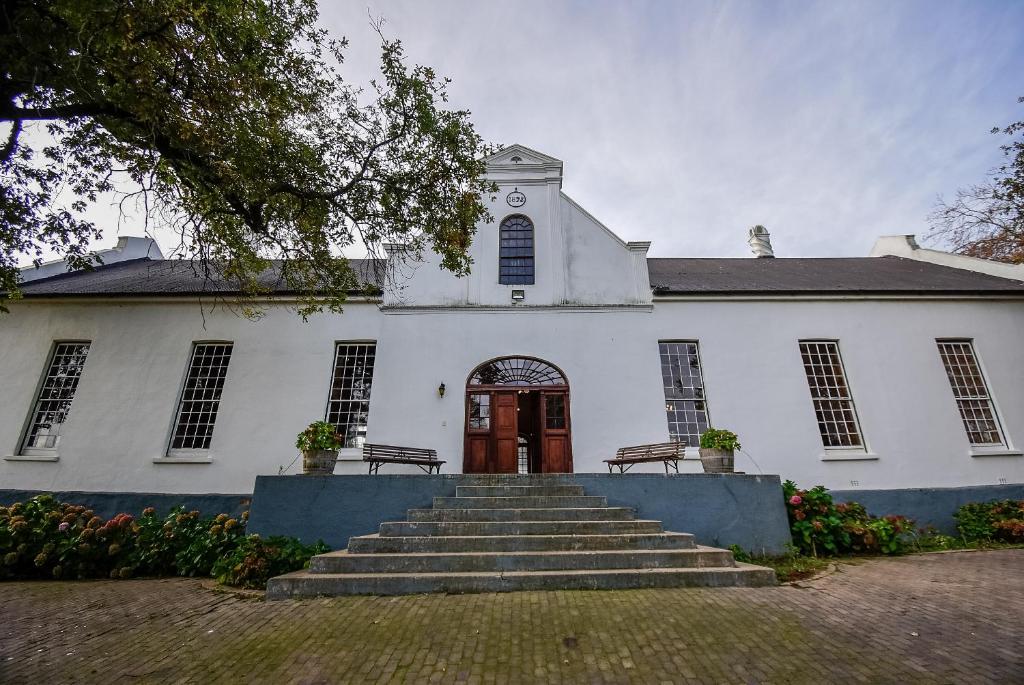 uma igreja branca com escadas que levam a uma porta em Heins Manor House em Stellenbosch