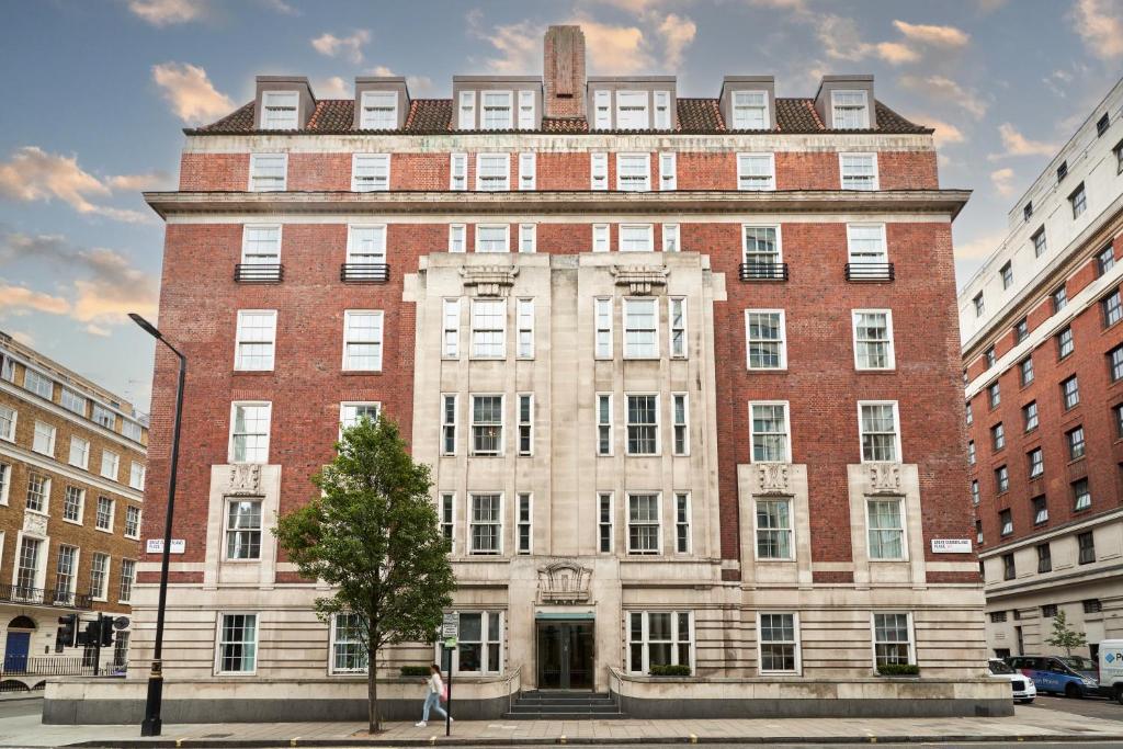 duży budynek z czerwonej cegły w mieście w obiekcie Thistle London Park Lane w Londynie