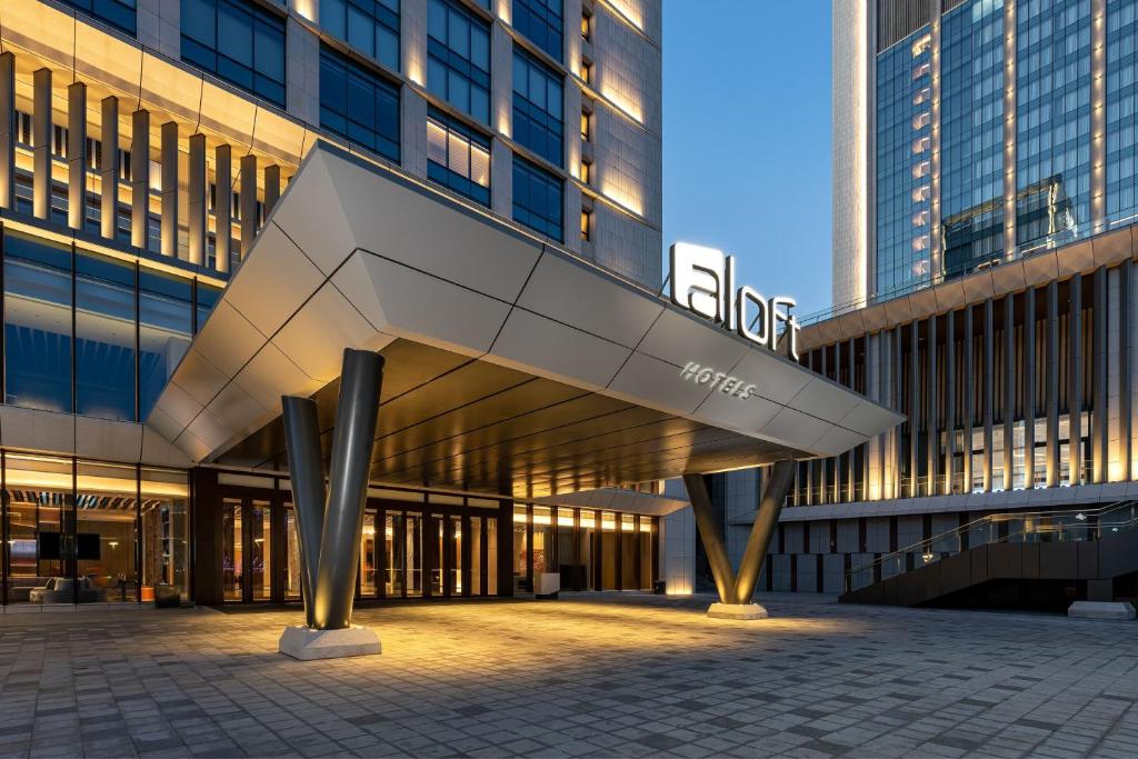 a view of a building with a sculpture in front of it at Aloft Yantai in Yantai