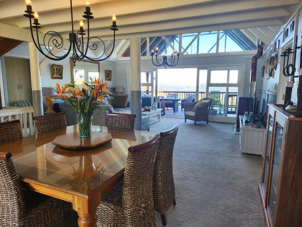 a dining room and living room with a table and chairs at Knysna River View in Knysna