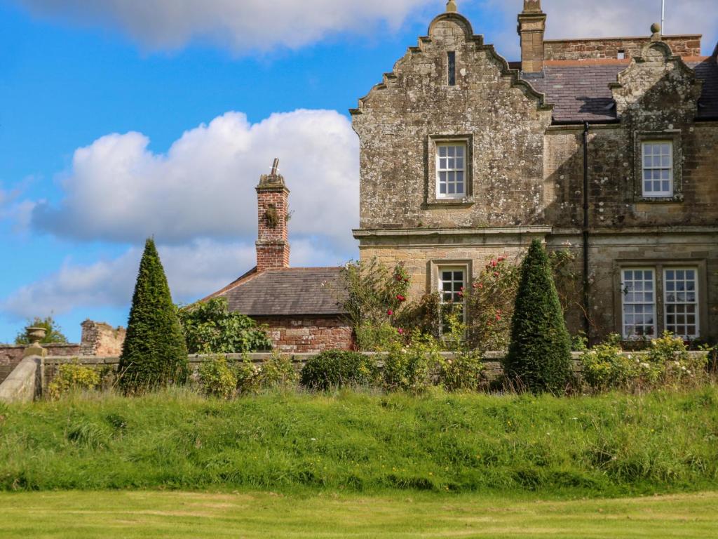 una antigua casa de piedra con chimenea y torretas en The Pavillion en Carlisle