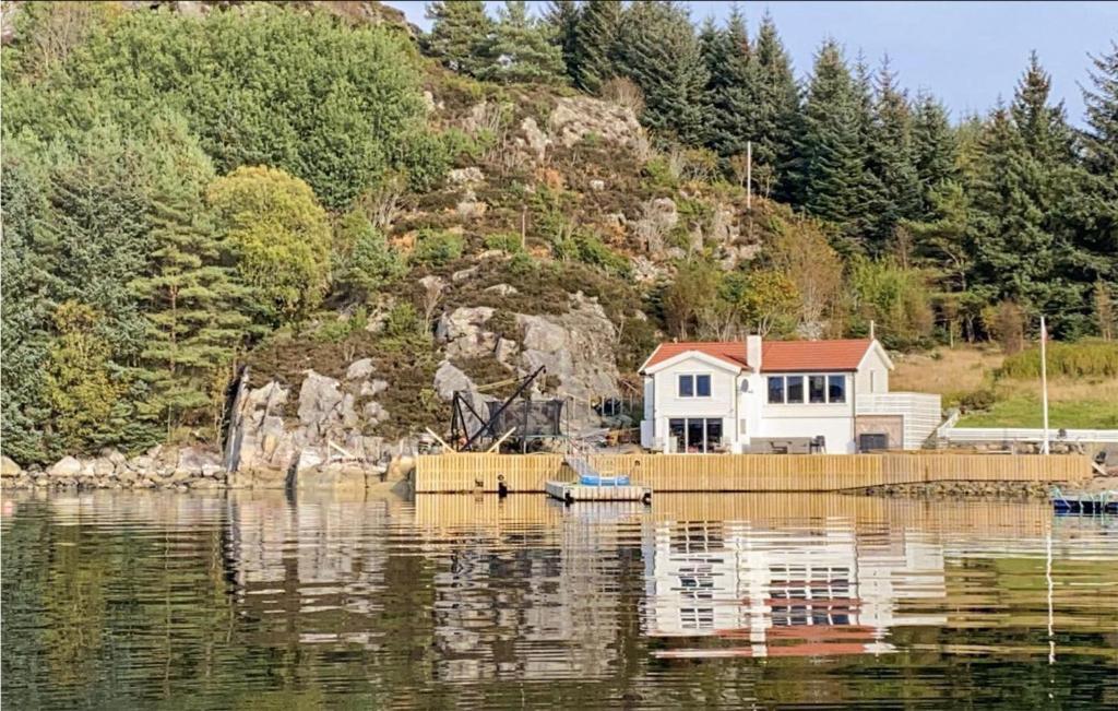 a house sitting on the water next to a house at Stunning Home In Fitjar With Wifi in Fitjar