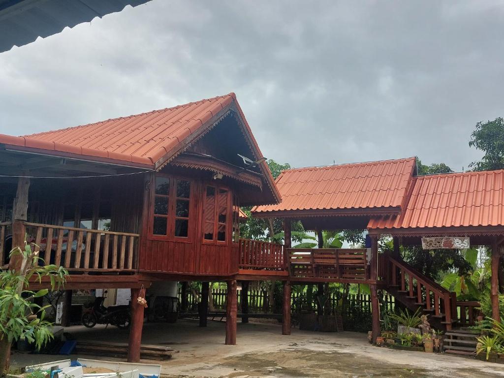 a large wooden house with a large deck at Duangmanee homestay 