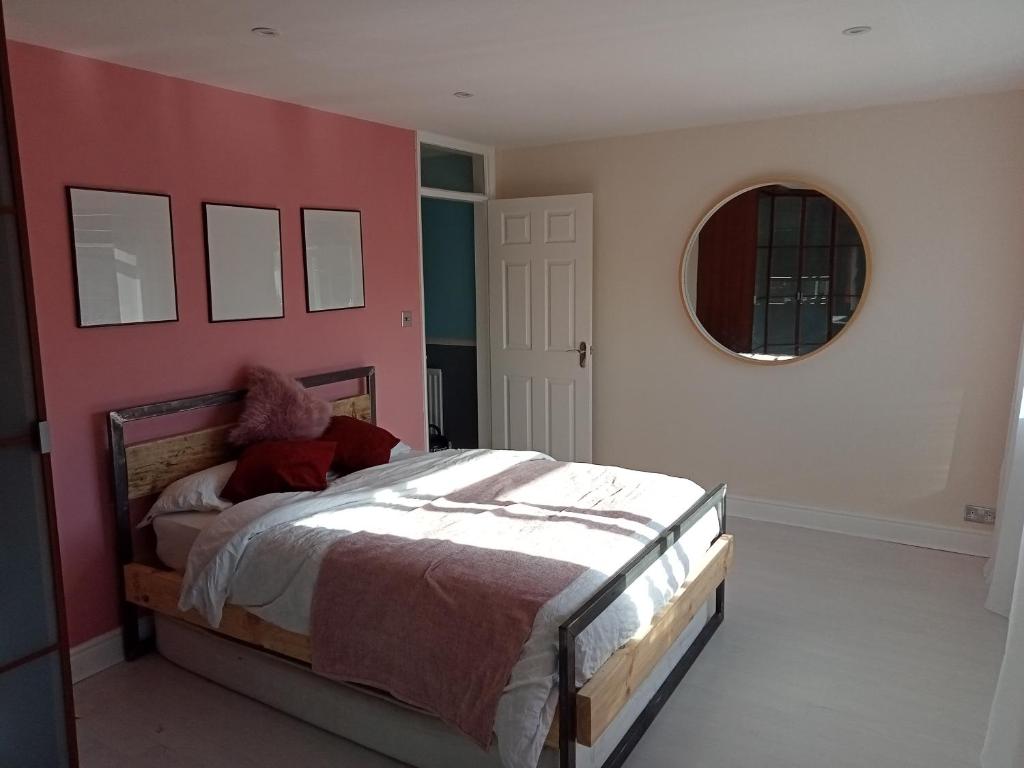 a bedroom with a bed with a red wall at 32 Station Road in Higham on the Hill