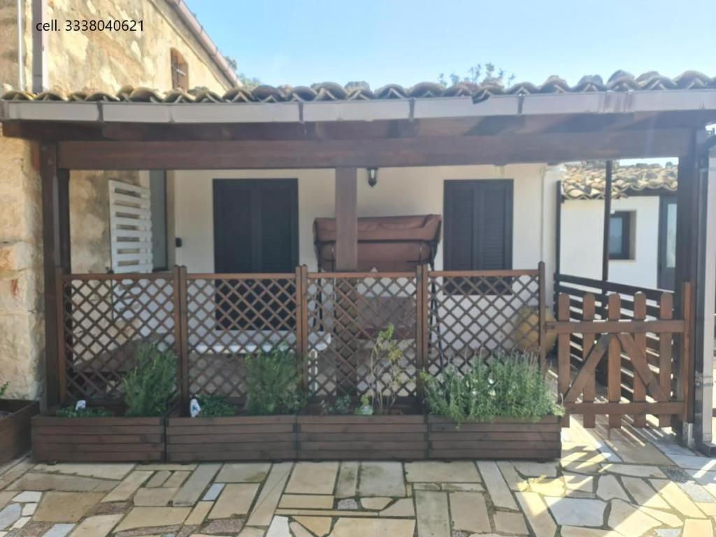 een houten pergola met een hek op een patio bij La Casetta in Santa Croce Camerina