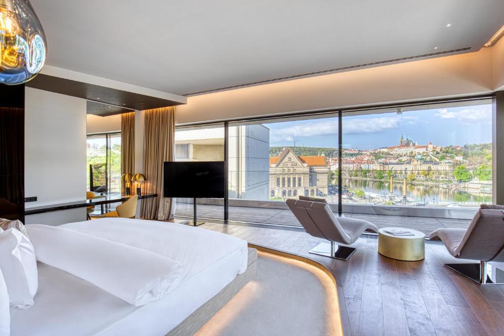 um quarto de hotel com uma cama grande e uma janela grande em The President em Praga