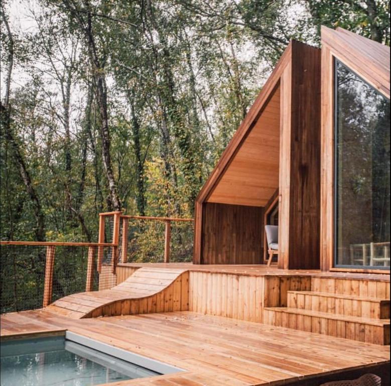 uma casa com um deque e uma piscina em Casa Slow avec sa piscine chauffée au bord du lac em Les Croix Chemins