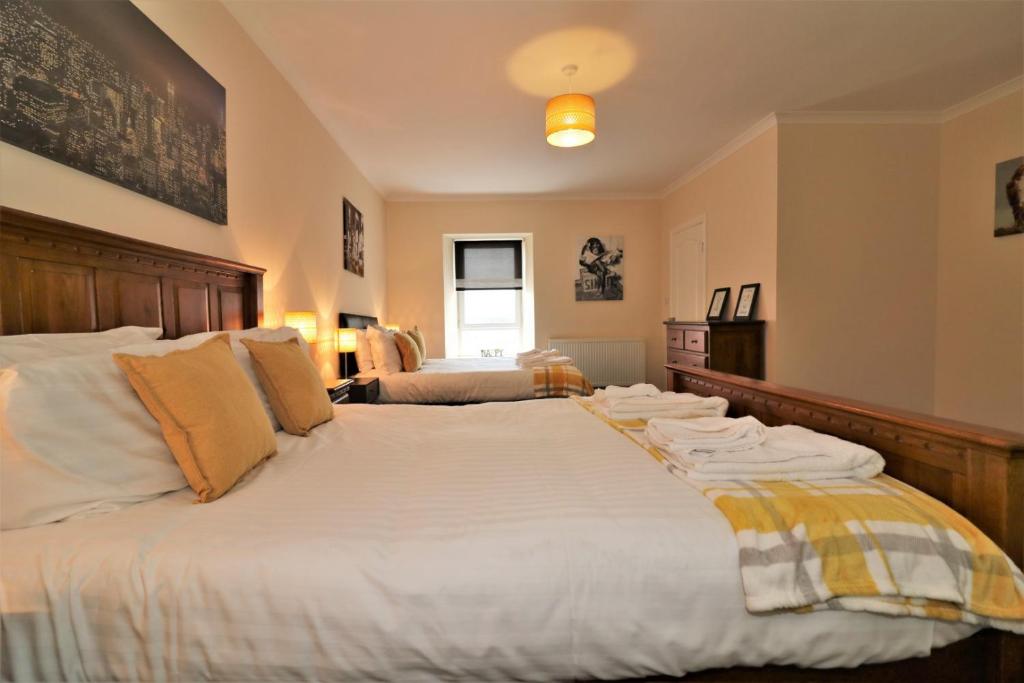 a bedroom with a large bed with towels on it at Signature - Kirkhill House in Kirkmuirhill