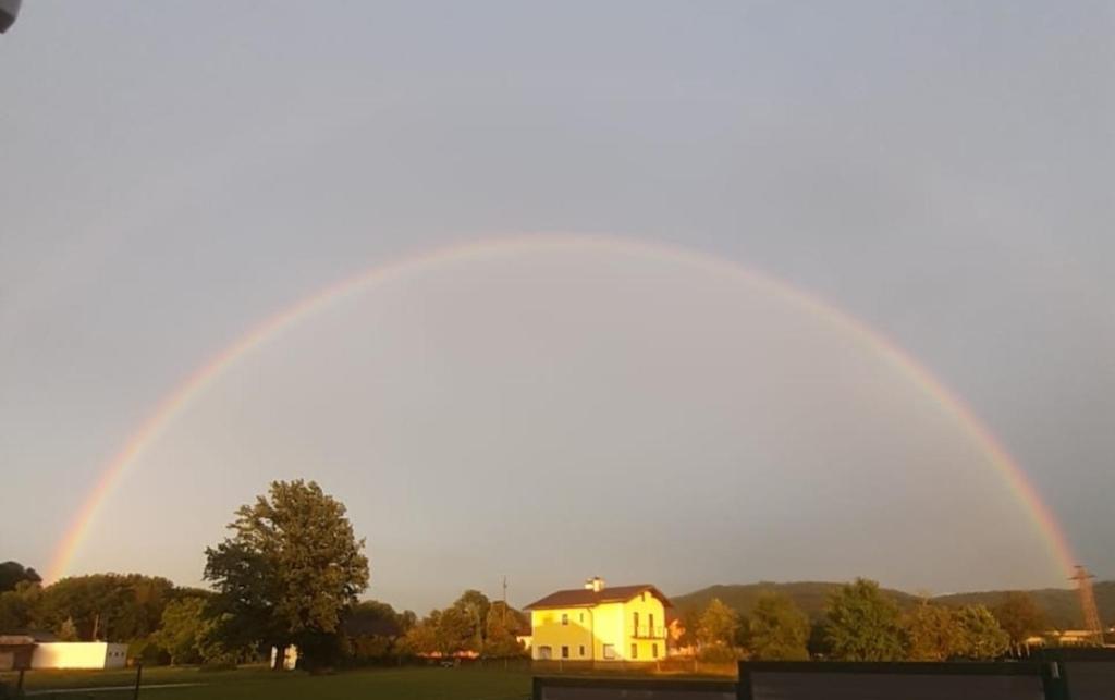 Ein Regenbogen über einem Haus in der Unterkunft Ferienwohnung ländlich und in Seenähe in Schörfling