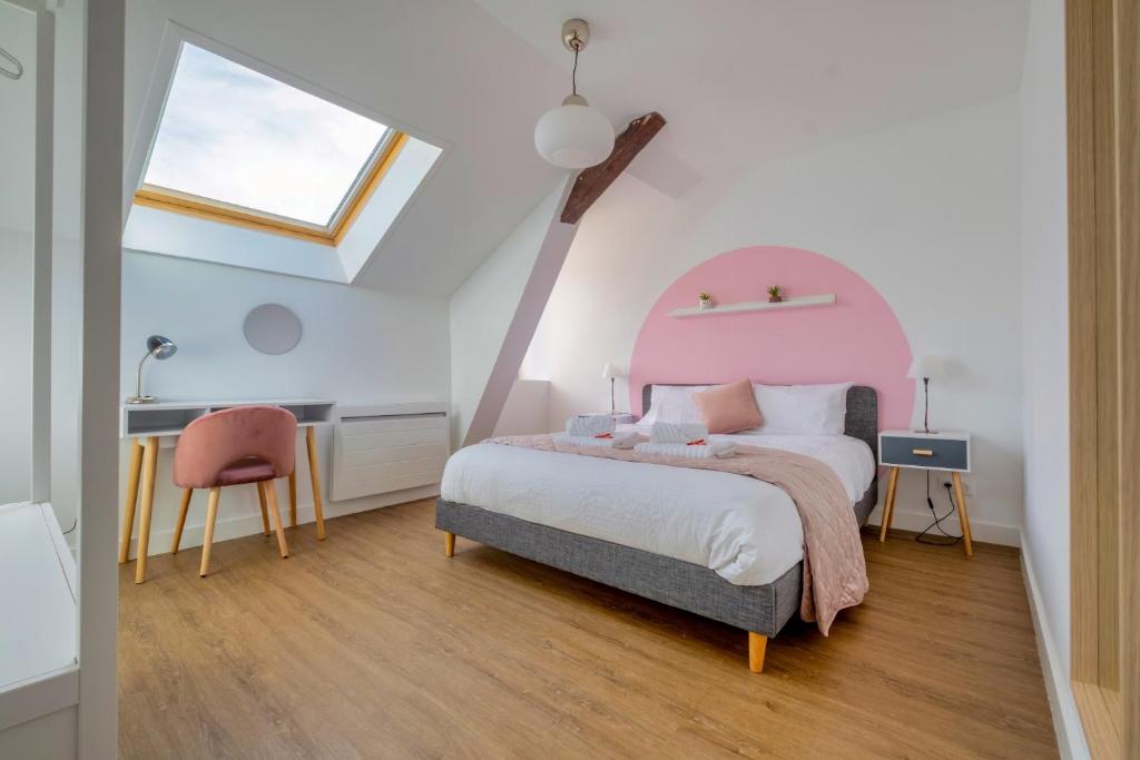 a bedroom with a pink bed and a desk at Sainte-Anne in Reims