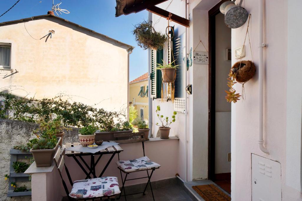 a small balcony with potted plants and a table at Ca' a riga in Diano Castello