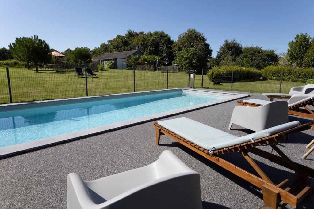uma piscina com espreguiçadeiras e uma piscina em Maison Névez Campagne Calme Piscine em Clohars-Fouesnant