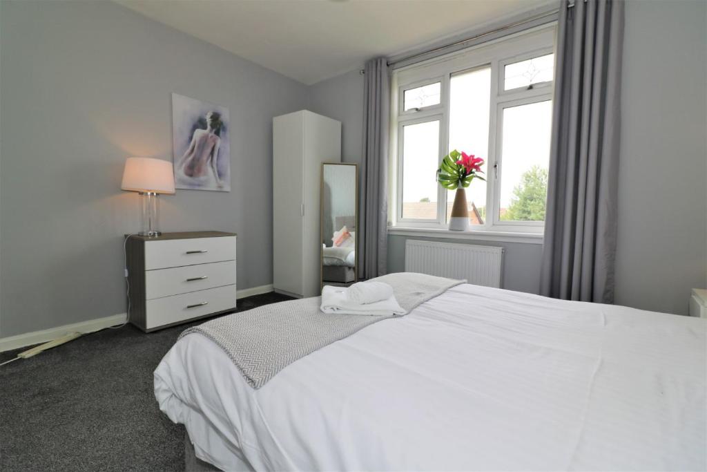 a bedroom with a white bed and a window at Signature - Carfin House in Carfin