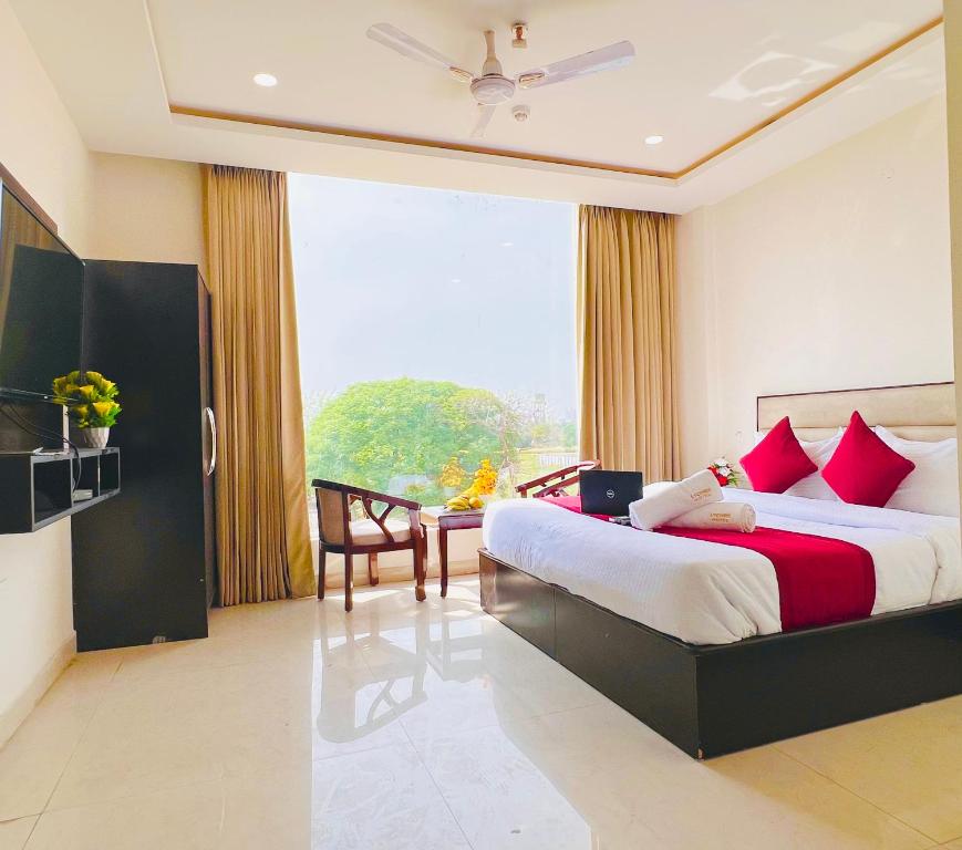 sypialnia z dużym łóżkiem z czerwonymi poduszkami w obiekcie Stay @Northview park hotel zirakpur w mieście Zirakpur
