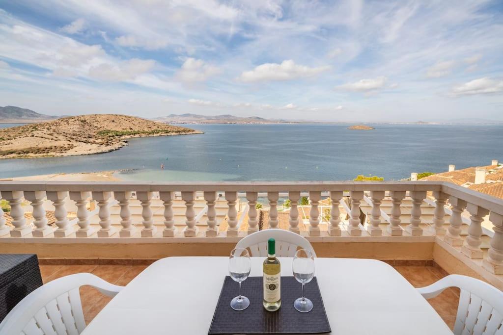 a table and chairs on a balcony with a view of the ocean at Villas Romanas with best sunsets and views in Cartagena