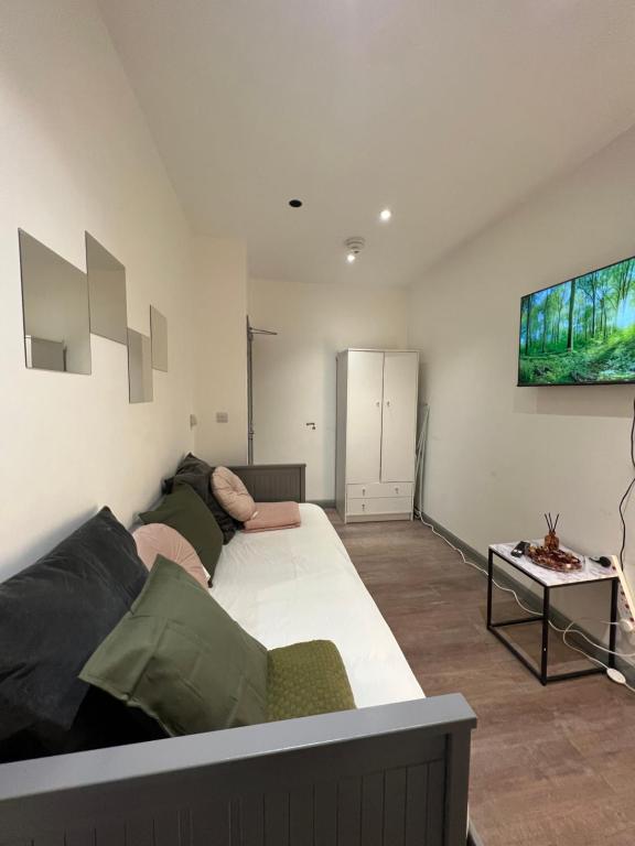 een slaapkamer met een groot bed en een bank bij 3 Bedroom Flat in King’s Cross, St Pancras’s. 2 minutes to Euston. in Londen
