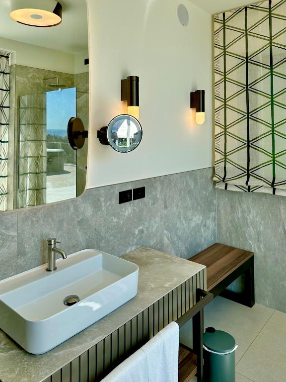 a bathroom with a sink and a mirror at Maximilian Suites in Trieste