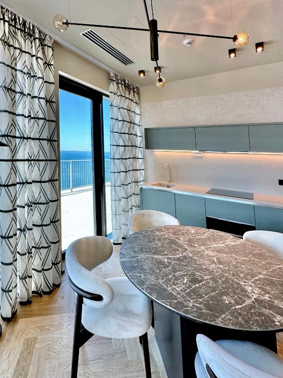 a kitchen with a table and chairs and the ocean at Maximilian Suites in Trieste