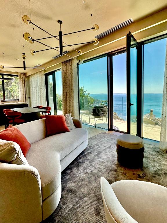 a living room with a couch and a table and glass doors at Maximilian Suites in Trieste
