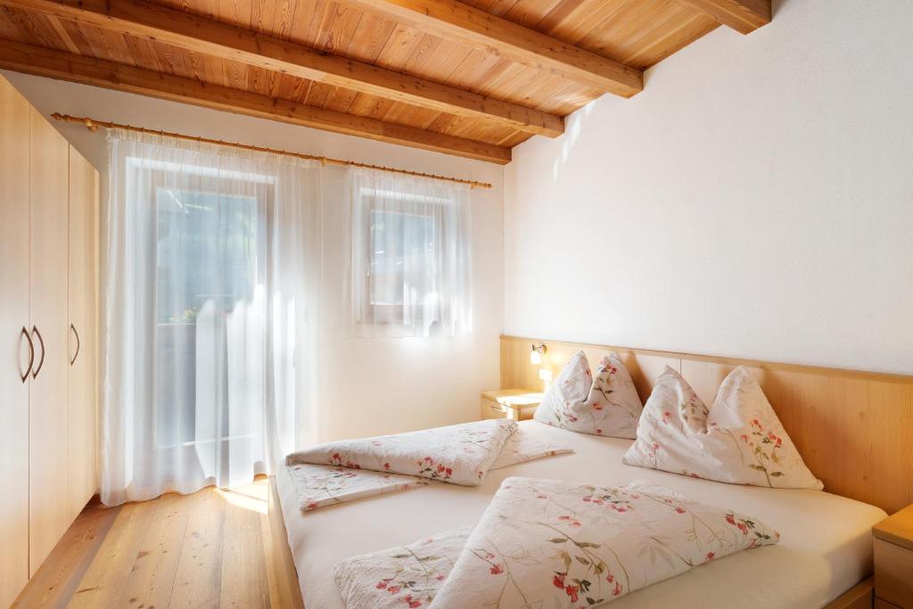 um quarto com uma cama com almofadas e uma janela em Speckign Apartment 2 em Cadipietra