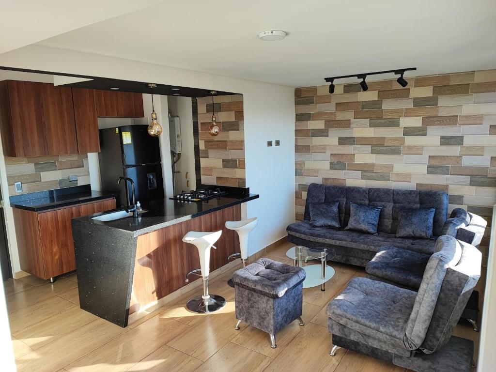 a living room with a couch and a kitchen at Apartamento cerca al aeropuerto in Rionegro