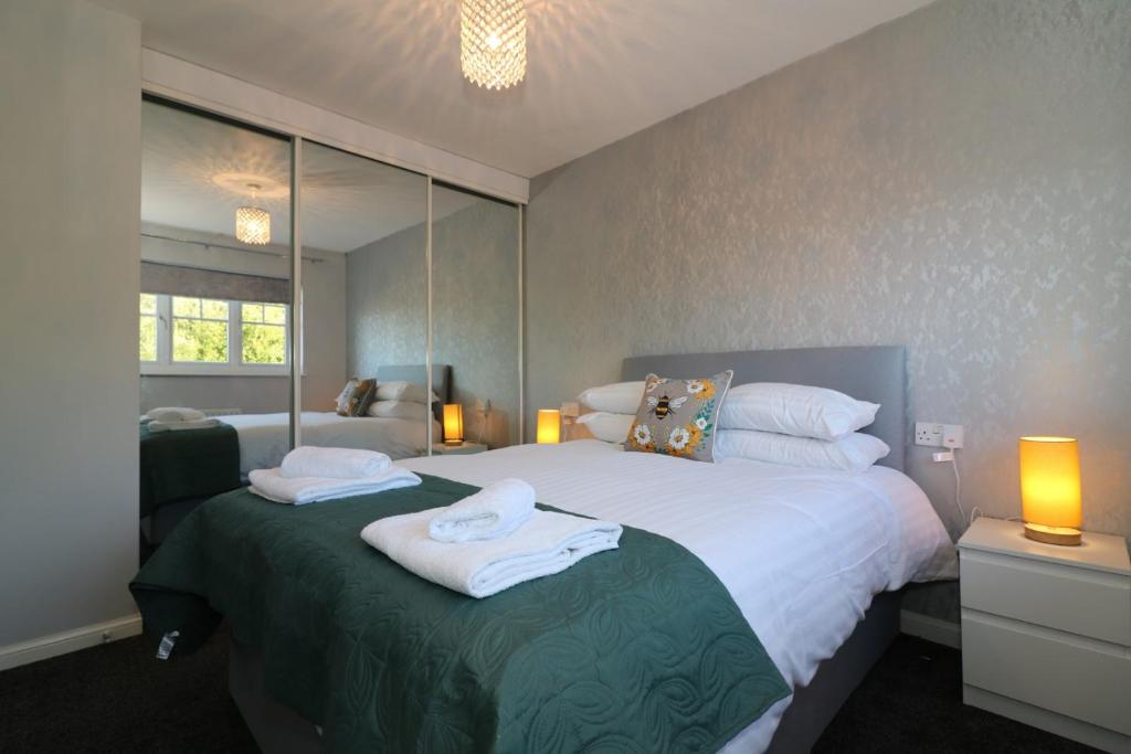 a bedroom with a large bed with towels on it at Signature - Chapelhall House in Chapelhall