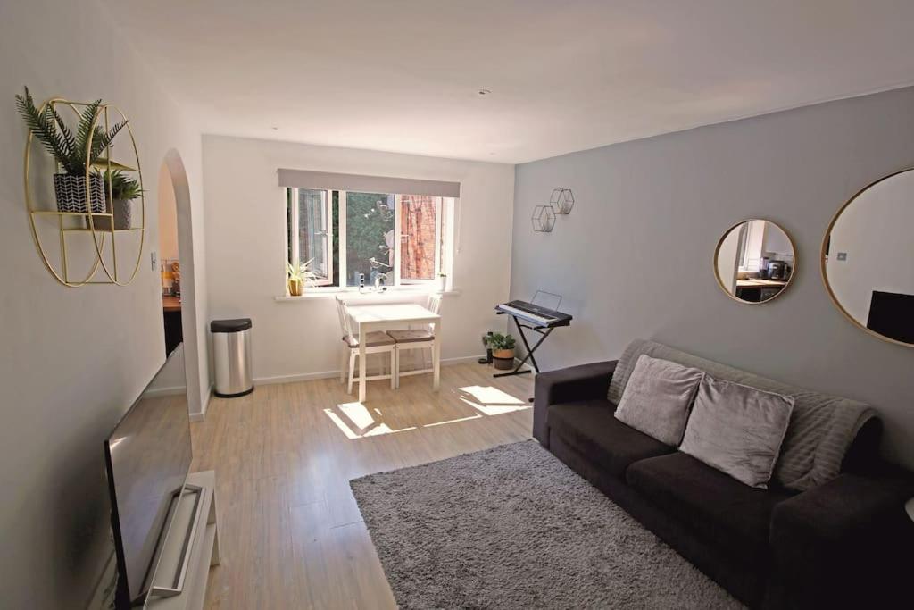 uma sala de estar com um sofá e um espelho em Entire 2 Bed Apartment in Manchester em Manchester