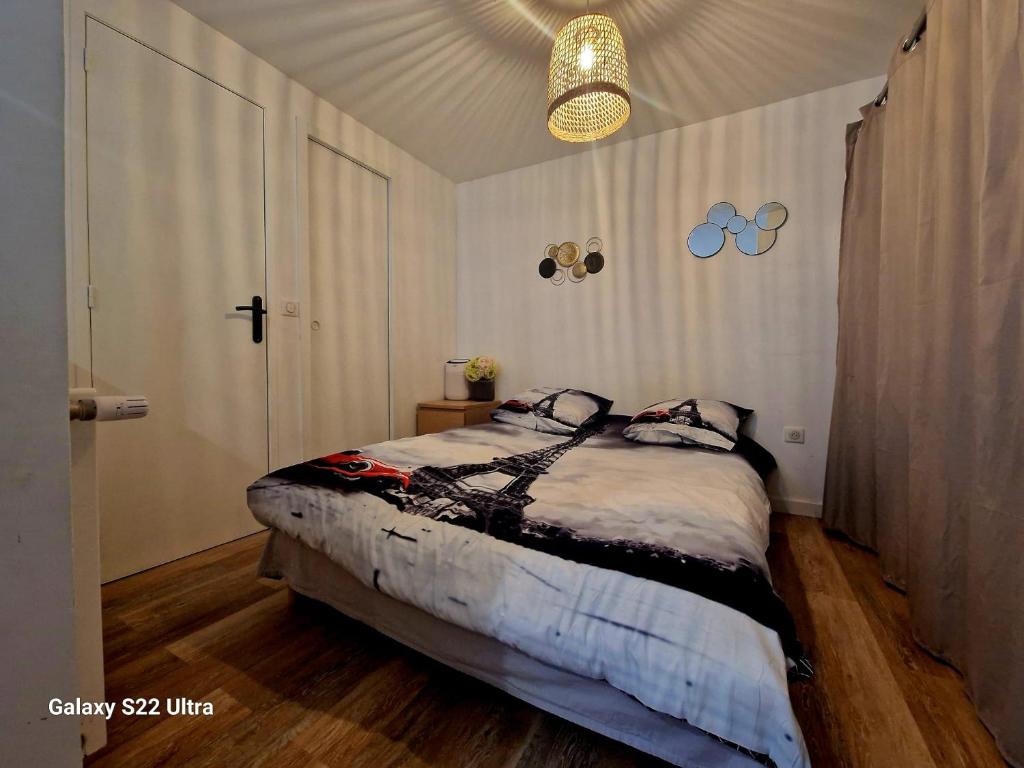 a bedroom with a bed and a ceiling at Charment studio proche Paris 15 in Malakoff