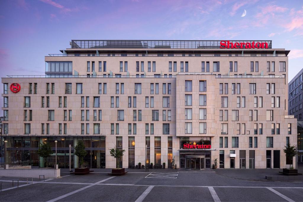a large white building with a red sign on it at Sheraton Bratislava Hotel in Bratislava