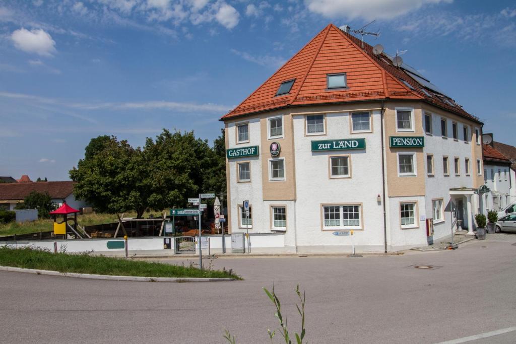 un grand bâtiment blanc avec un toit orange dans l'établissement Gasthof zur Länd, à Moosburg an der Isar